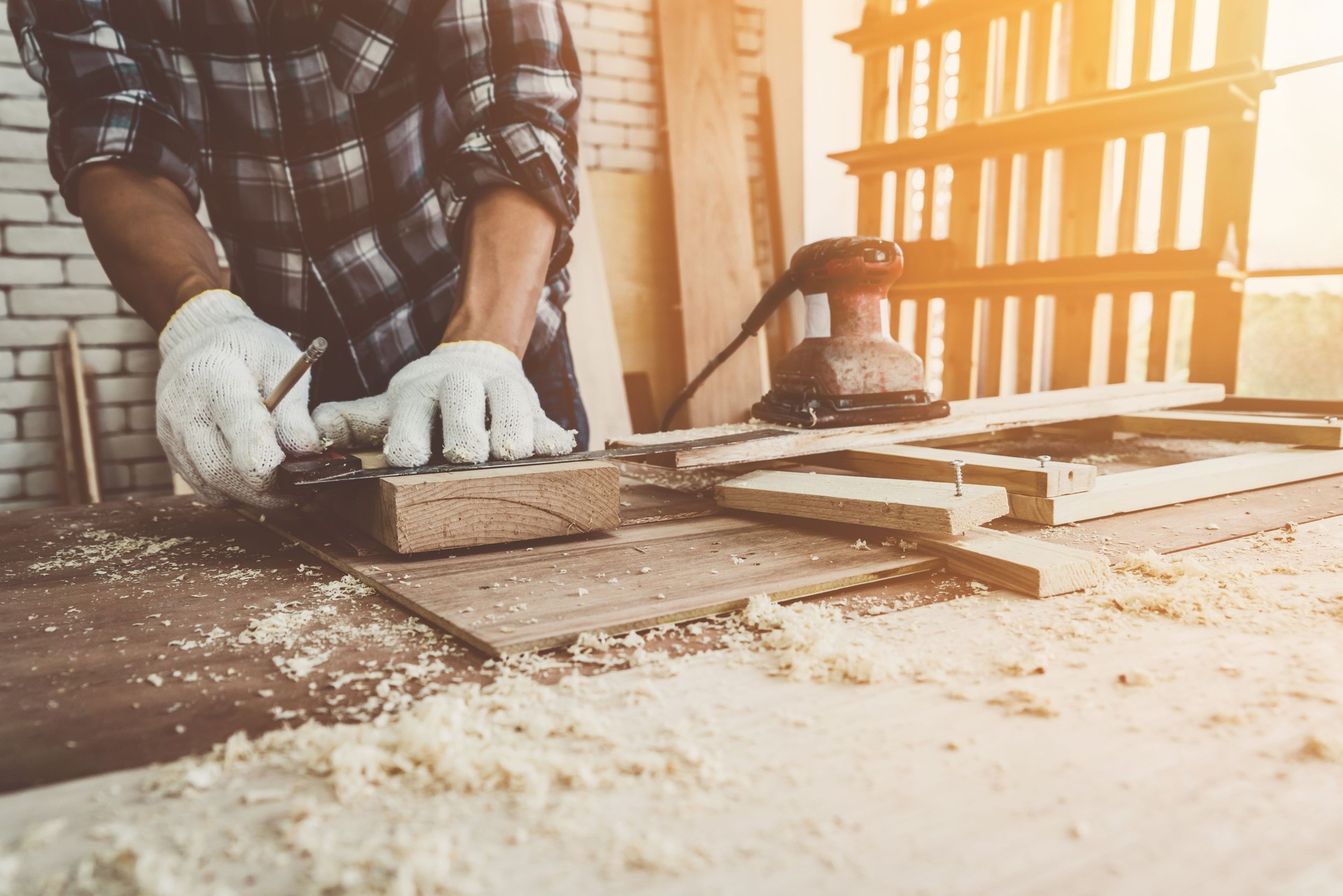 Carpenter working on wood craft at workshop to produce construction material or wooden furniture. The young Asian carpenter use professional tools for crafting. DIY maker and carpentry work concept.